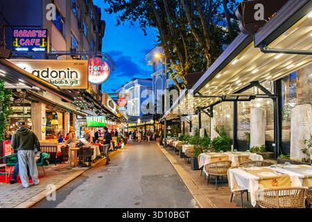 Beleuchtete Straßencafés und Geschäfte im farbenfrohen Sultanahmet-Viertel von Istanbul Türkei bei Nacht. Stockfoto