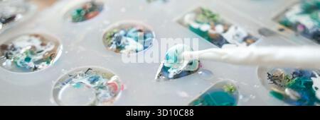 Kreativer Kunstharzprozess mit farbenfrohen Designs in Formen, die einzigartige Handwerks- und Schmuckherstellungstechniken zeigen. Stockfoto
