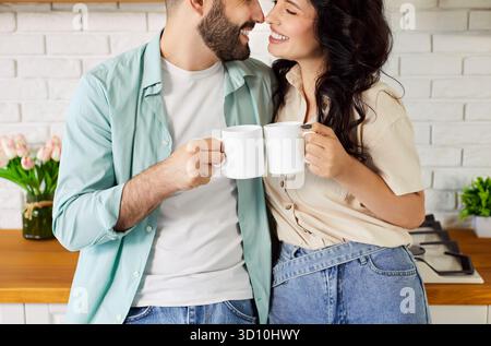 Glückliches Paar trinkt Kaffee und umarmt sich liebevoll, die Leute genießen Heißgetränke Stockfoto