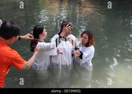 Yardenit Taufstätte, protestantische indonesische Frau trägt ein weißes Kleid, betet und gehalten von einem sie Pastor (L), um im Jordan von 2 Frauen getauft zu werden Stockfoto
