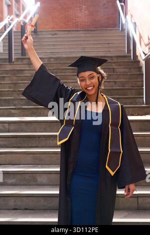 Graduiertenfrau feiert Bildungsleistung mit Diplom Stockfoto