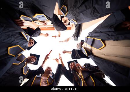 Absolventen, die Diplome ausstellen, um akademische Erfolge zu feiern Stockfoto