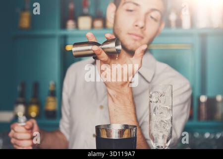 Barkeeper gießt Sirup in das Messglas Stockfoto
