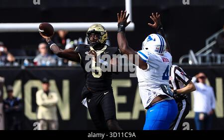 25. Oktober 2025: Der Quarterback der Wake Forest University Deshawn Purdie (5) übergibt den Ball vor dem SMU Defensive Tackle Terry Webb (4). NCAA-Fußballspiel zwischen der Southern Methodist University und der Wake Forest University im AlLegacy Federal Credit Union Stadium in Winston-Salem, North Carolina. David Beach/CSM Stockfoto