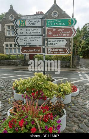 Zweisprachige Straßenschilder auf Gälisch und Englisch gruppiert an einem Pol in der Republik Irland Stockfoto