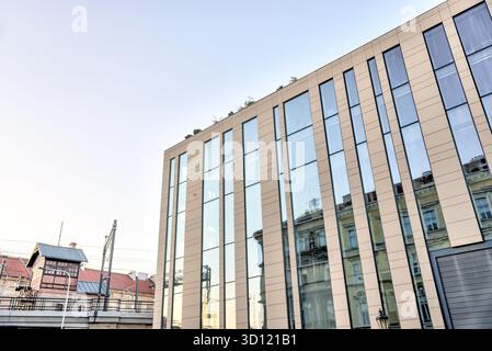 Modernes Bürogebäude aus Glas und Metall in Prag, Tschechien, mit scharfen vertikalen Lamellen, die sich gegen den klaren Morgenhimmel erheben. Stockfoto