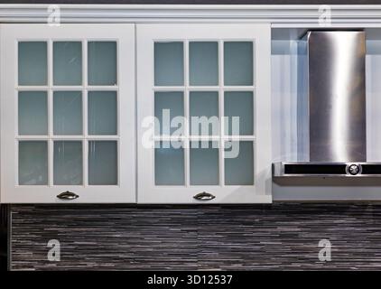 Moderne Kücheneinrichtung mit schwarz-weißen Fliesen und Luftkanalgerät Stockfoto