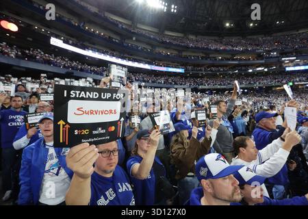 Toronto, Kanada. Oktober 2025. Baseballfans halten Karten, die ihre Unterstützung für die Krebsforschung während des zweiten Spiels der MLB World Series zwischen den Los Angeles Dodgers und den Toronto Blue Jays im Rogers Centre in Toronto zeigen, Kanada, am Samstag, den 25. Oktober 2025. Foto: Aaron Josefczyk/UPI Credit: UPI/Alamy Live News Stockfoto