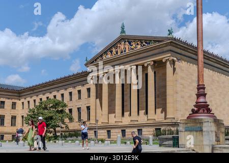 Eine Gruppe von Leuten läuft vor einem Philadelphia Museum of Art Das Gebäude ist braun und hat eine Kuppel oben Stockfoto