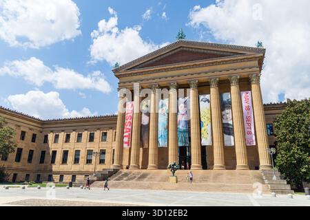 Das Philadelphia Museum of Art ist ein Museum mit einem großen Schild auf der Vorderseite. Das Gebäude ist braun und hat viele Säulen Stockfoto