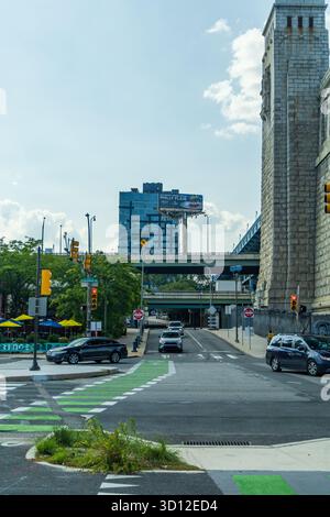 Eine geschäftige Stadtstraße mit einem großen Gebäude im Hintergrund. Die Straße ist gesäumt von Autos und ein paar Fußgängern. Rennen In St. Pier, Philadelphia Stockfoto