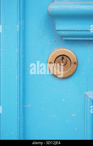 Hellblaue Tür mit Schlüssellochdetail aus Messing Stockfoto
