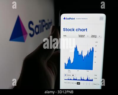 In dieser Abbildung hält eine Person ein Smartphone mit der Webseite des Softwareunternehmens SailPoint Technologies Inc. Auf dem Bildschirm vor dem Logo. Stockfoto
