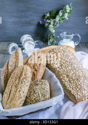 Frisch gebackenes, handwerkliches Brotsortiment mit Sauerteig, Mehrkornbrot und Baguettes in rustikalem Ambiente Stockfoto