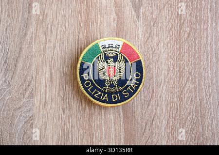 KIEW, UKRAINE - 6. SEPTEMBER 2025 Flicken der italienischen Staatspolizei auf brauner hölzerner Tischoberfläche Nahaufnahme Stockfoto