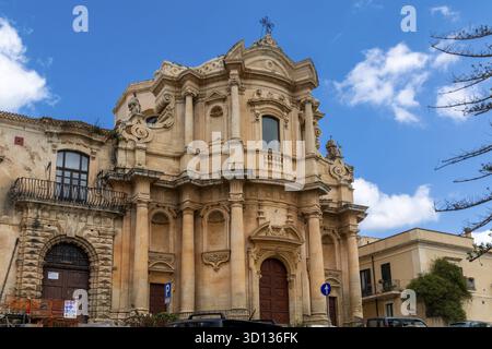 Noto, Sizilien - Italien - 04-06-2025: Aufwendige barocke Kirchenfassade mit skulpturalen Details, hohen Säulen, bogenförmigen Türen und dekorativem Elem Stockfoto