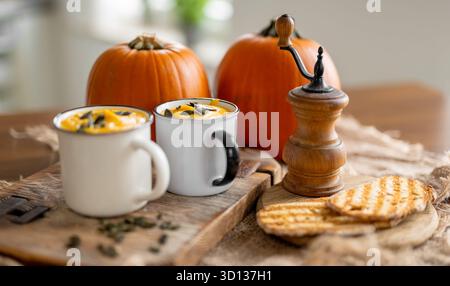 Rustikale Komposition Mit Kürbissuppe Und Kürbissen In Bechern Stockfoto