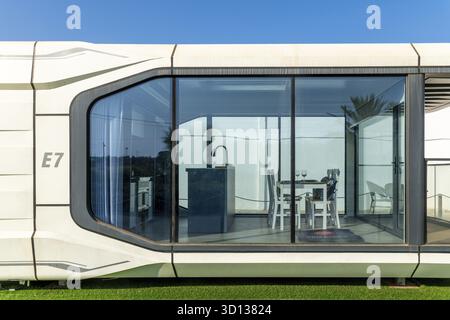 Almancil, Algarve - Portugal - 19.09.2024: Nahaufnahme des modularen Gebäudes E7 mit großer Glasfront, minimalistischer Inneneinrichtung, Esstisch, Waschbecken, umgeben Stockfoto