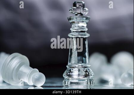 Glas-Schachbrettspiel in schwarzem Hintergrund, selektiver Fokus auf König, Führung, Siegerkonzept Stockfoto
