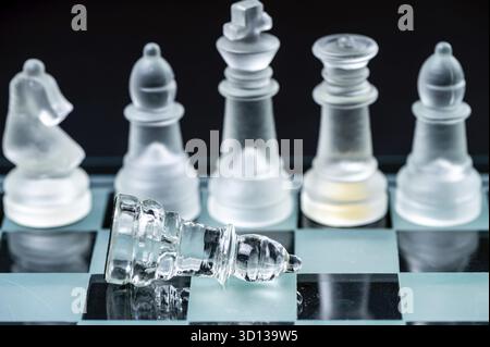 Klares Glas, transparente Schachfiguren auf einem Schachbrett, selektiver Fokus, Nahaufnahme, isoliert auf Schwarz Stockfoto