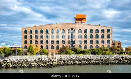 Brooklyn, New York, USA, industrielle Backsteinarchitektur entlang der Red Hook Küste unter dramatischem Himmel. Stockfoto