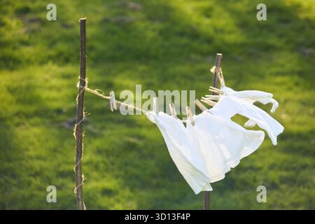 Gewaschene Kleidung trocknet auf einer Wäscheleine im Hof Stockfoto