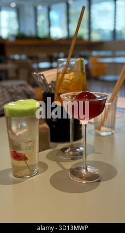 Farbenfrohe Cocktails auf dem Tisch in gemütlicher Bar mit lebhaften Getränken und moderner Einrichtung. Mobiles Foto Stockfoto