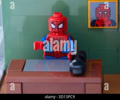 Tambow, Russische Föderation - 12. Februar 2025 Lego Spider-man sitzt hinter dem Tisch im Büro. Nahaufnahme Stockfoto