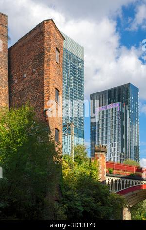 Ein Fabrikgebäude aus dem 19. Jahrhundert mit dem Beetham- und Viadux-Turm dahinter. Vom Rochdale Canal, in der Nähe von Castlefield, Manchester, England, Großbritannien Stockfoto