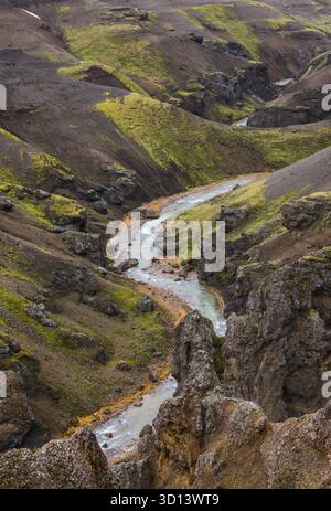 Fluss mit roten Ufern und schwarz-roten Lava schneebedeckten Bergen in Kerlingarfjoll auf Island, IJsland Stockfoto