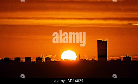 Glasgow, Schottland, Großbritannien. Oktober 2025. Wetter in Großbritannien: Der Herbst erscheint, wenn ein roter Sonnenaufgang die Uhren begleitet, die über die Skyline von Gotham im Westen der Stadt zurückreichen. Credit Gerard Ferry/Alamy Live News Stockfoto
