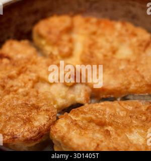Goldene gebratene Hähnchenkoteletts in einer Pfanne. Knusprige Textur und appetitliches Aussehen. Ideal für kulinarische Themen und kulinarische Präsentationen Stockfoto
