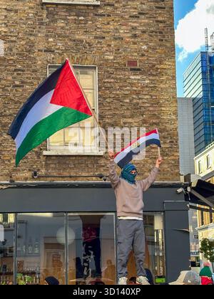 11. November 2023: Ein Demonstrant hält die Flaggen Ägyptens und Palästinas beim Nationalmarsch gegen den Krieg in Gaza, London, Vereinigtes Königreich Stockfoto