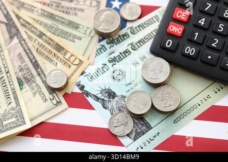 US-Dollar-Geldscheine und Taschenrechner auf amerikanischer Flagge Nahaufnahme. Geldinvestitionskonzept und Steuerzahlung Stockfoto