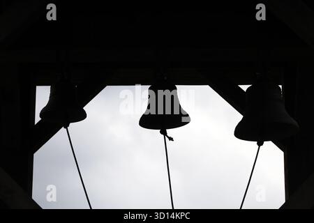 Kirchenglocken Silhouetten in einem Glockenturm vor einem hellen Himmel Stockfoto