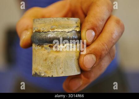 Metallrohr mit einer Schweißnaht in der Hand des Menschen des Schweißers Stockfoto