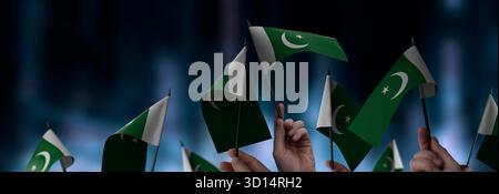 Pakistanische Flaggen in den Händen vor einem verschwommenen urbanen Hintergrund. Die Fotoillustration wurde ohne künstliche Intelligenz erstellt, nur mit Photoshop. Stockfoto