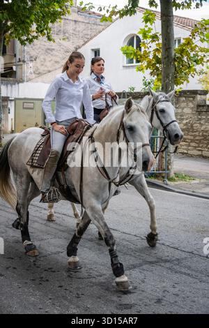 Mutter und Tochter reiten bei der Prozession der Wächter in San Remy de Provence, Frankreich. Stockfoto