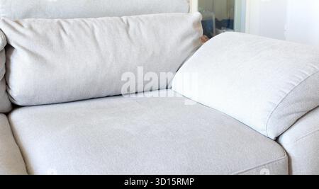 Stoffsofa mit Nahaufnahme des hellen Polstermaterials, geeignet für Innenarchitektur, Wohnmöbel und Textilreinigungslösungen Stockfoto