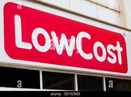 Ladenvorderseite mit auffälligem rot-weißem Design, auf dem das Wort Low Cost über einer Reihe von Fenstern steht C'an Pastilla Mallorca Cheap Concept Stockfoto
