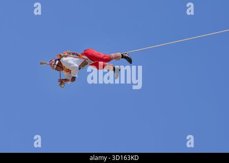 Crisanto Méndez Jiménez spielt Flöte und Trommel, während er und drei andere Voladores in Chapala, Mexiko, auf die Erde herabsteigen. Stockfoto