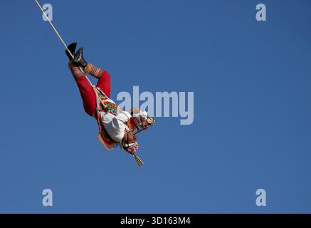 Crisanto Méndez Jiménez spielt Flöte und Trommel, während er und drei andere Voladores in Chapala, Mexiko, auf die Erde herabsteigen. Stockfoto