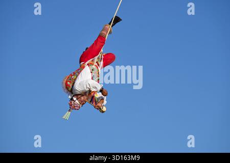 Crisanto Méndez Jiménez spielt Flöte und Trommel, während er und drei andere Voladores in Chapala, Mexiko, auf die Erde herabsteigen. Stockfoto