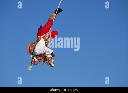 Crisanto Méndez Jiménez spielt Flöte und Trommel, während er und drei andere Voladores in Chapala, Mexiko, auf die Erde herabsteigen. Stockfoto