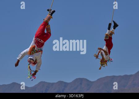 Crisanto Méndez Jiménez (rechts) spielt Flöte und Trommel, während er und andere Voladores in Chapala, Mexiko, auf die Erde herabsteigen. Stockfoto