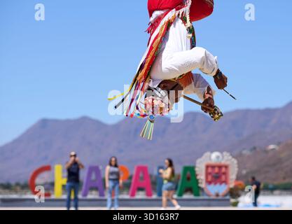 Crisanto Méndez Jiménez spielt Flöte und Trommel, während er und drei andere Voladores in Chapala, Mexiko, auf die Erde herabsteigen. Stockfoto