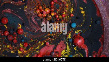 Bunte Blasen. Bokeh-Öl. Unscharfe lila gelbe rote Glitzer runde Textur funkelnde flüssige Farbe auf abstraktem Acrylkunsthintergrund. Stockfoto