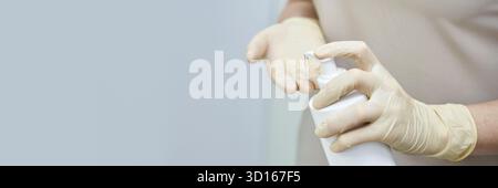 Kaukasische Frau mit Handschuhen zur Handhygiene auf hellem Hintergrund. Stockfoto