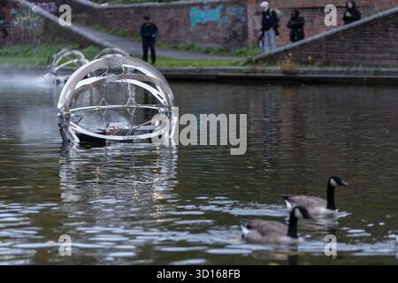 Dudley, West Midlands, Großbritannien. Oktober 2025. Eine faszinierende Flotte von drei beleuchteten, schwimmenden Skulpturen, Water Bots, an der Dudley No.2-Kanal-Kreuzung am Windmill End in der Nähe von Dudley im Herzen des industriellen Black Country, West Midlands. Der Künstler Michael Candy hat Water Bots als bahnbrechende Fusion von Kunst und Technik geschaffen. Es ist vom industriellen Erbe der Region West Midland inspiriert und wurde von Birmingham Open Media in Auftrag gegeben. Quelle: Peter Lopeman/Alamy Live News Stockfoto