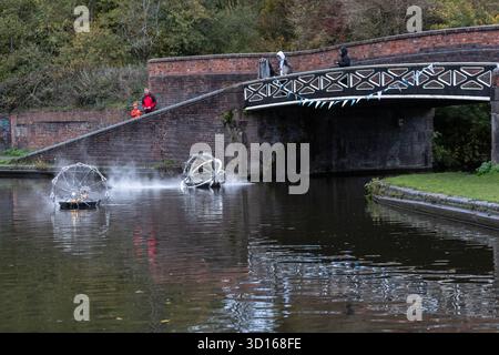 Dudley, West Midlands, Großbritannien. Oktober 2025. Eine faszinierende Flotte von drei beleuchteten, schwimmenden Skulpturen, Water Bots, an der Dudley No.2-Kanal-Kreuzung am Windmill End in der Nähe von Dudley im Herzen des industriellen Black Country, West Midlands. Der Künstler Michael Candy hat Water Bots als bahnbrechende Fusion von Kunst und Technik geschaffen. Es ist vom industriellen Erbe der Region West Midland inspiriert und wurde von Birmingham Open Media in Auftrag gegeben. Quelle: Peter Lopeman/Alamy Live News Stockfoto